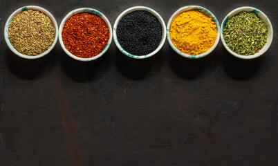 Traditional oriental spices in ceramic bowls. black cumin seed, ground red pepper, dried mint, himalayan ​​salt.