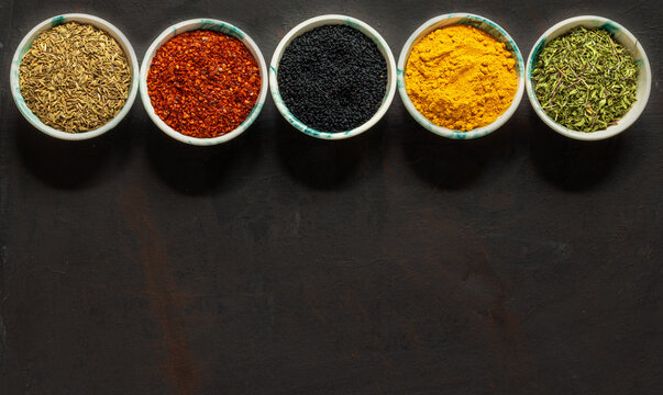 Traditional oriental spices in ceramic bowls. black cumin seed, ground red pepper, dried mint, himalayan ​​salt.