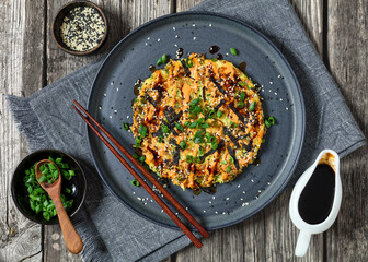 Japanese pancake with cabbage on a plate, top view