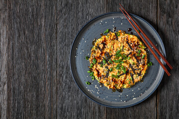 Japanese pancake with cabbage on a plate, top view