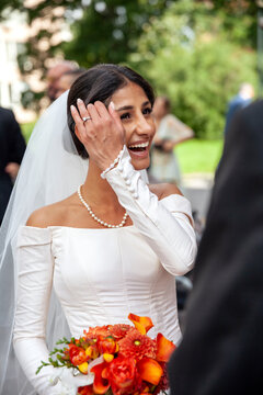 Cheerful bride carrying bouquet after wedding ceremony