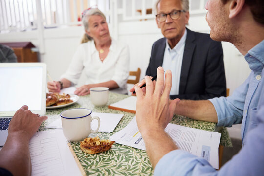 Business coworkers discussing strategy while sitting at desk in office during meeting