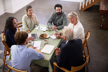 High angle view of business colleagues discussing strategy while sitting at desk in office during meeting