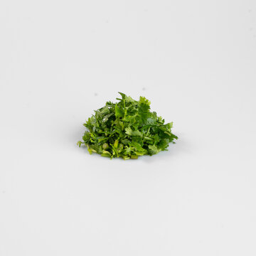 A small pile of fresh chopped greenery on a plain white background, ideal for culinary and food-related uses.