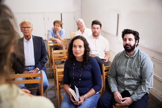 Colleagues sitting in office during presentation by businesswoman