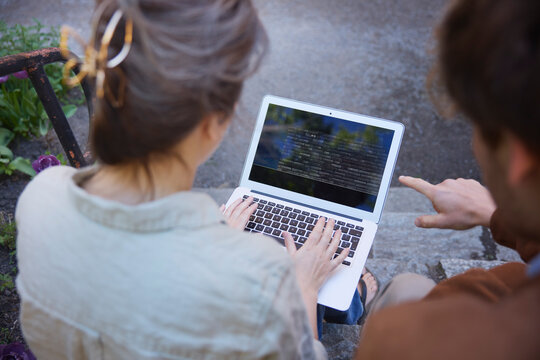 Cropped image of husband helping wife to use laptop