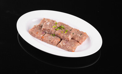 A white plate of savory meatloaf slices garnished with herbs, served on a black background. Perfect for culinary presentations.