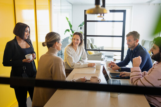 Multiracial corporate employees discussing new ideas while sitting over table in office