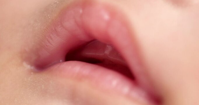 Close up of baby girl's pink lips that appear to have no teeth yet