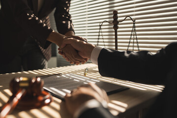 A lawyer shakes hands with a businessman to conclude a deal. investment contract Doing business with a lawyer Discussion of contract terms handshake concept Joint investment in joint legal contracts.