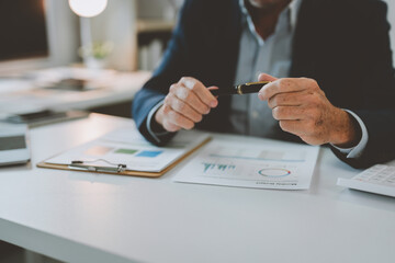 A skilled businessman sits at a desk and uses a computer to analyze online business marketing data....