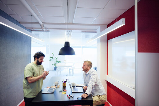 Young businessman making list during meeting with project manager