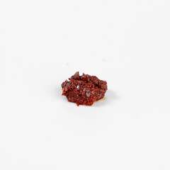Close-up of a small pile of dried chili flakes on a white background. Ideal for culinary, spice, and ingredient-themed images.