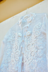 Wedding dress hanging on white wall