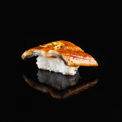 Close-up of delicious sushi with eel and rice, beautifully presented on a black background with...