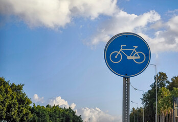 a blue circular bicycle sign at the bike path
