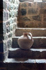 Earthenware jug on the steps of an old house.