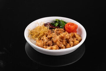 Delicious dish with crispy fried chicken, fresh greens, tomato, and shredded vegetables in a white bowl. Perfect for food presentations.