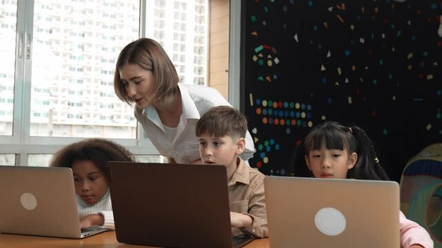Smart teacher teaching and looking student using laptop at classroom. Professional instructor explained about programing engineering code or prompt while studying and learning program. Erudition.
