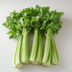 Pile of fresh, green celery stalks topped with parsley, arranged on a clean surface.