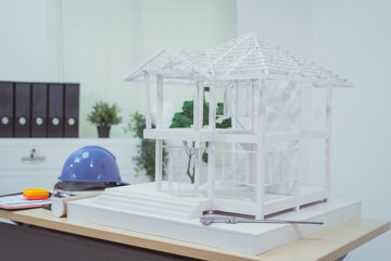 A home design company's office with a house sample placed on a desk, showcasing house structure...