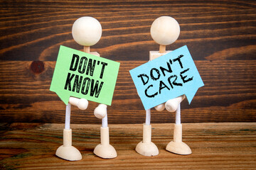 Don't know and  Don't care. Two speech bubbles on a wooden texture background