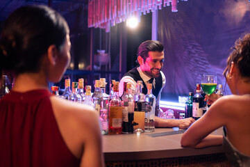 Caucasian profession bartender making a cocktail for customer at a bar. 