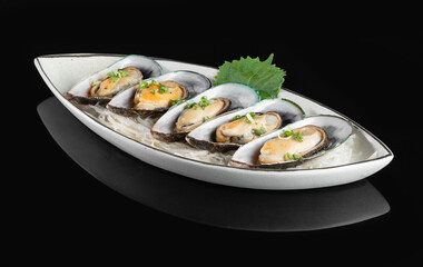 Elegant gourmet mussels served on a stylish plate with garnish, photographed on a reflective black surface for a sophisticated culinary presentation.