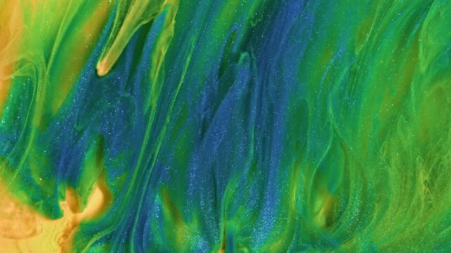 A mesmerizing blend of green, blue, and yellow acrylic paint flows in glittering waves, evoking a natural and fluid motion. Ideal for use in vibrant abstract designs and artistic backgrounds.