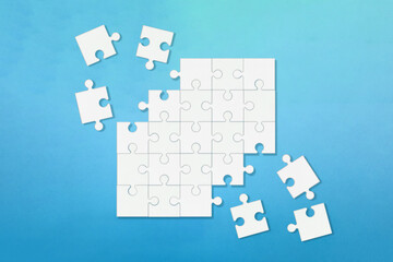 角がバラバラに欠けた青い背景の白いジグソーパズル