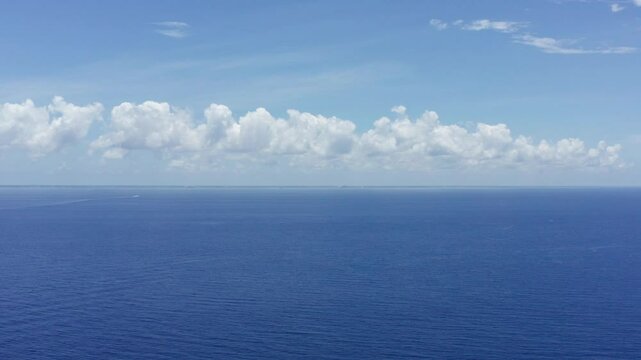 Super wide aerial shot across the Cozumel channel towards the island of Cozumel in Quintana Roo, Mexico. 4K