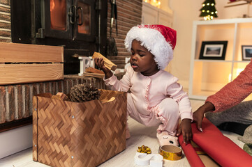 Little Girl in Santa Hat with Christmas Pinecone