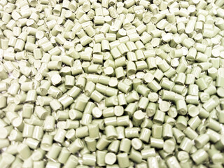 Green masterbatch granules. Polycarbonate type polymer with cold cutting. Inside laboratory pantry dish. Isolated on white background for industrial plastic product banner catalog design