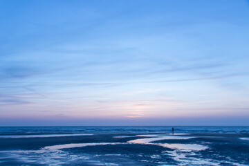 Silhouette sur une grande plage vide et l océan au crépuscule 