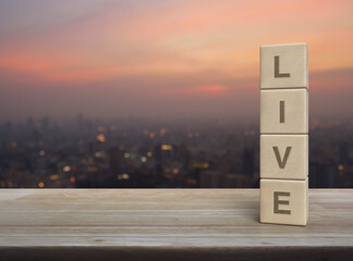 Live letter on wood block cubes on wooden table over blur of cityscape on warm light sundown, Technology broadcasting communication concept