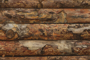 Wooden background of untreated logs, atmospheric timber wall, horizontal laying, copy space.