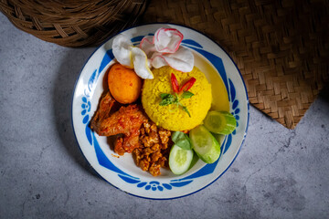 Indonesian traditional and signature dish, yellow rice served on an old plate. Top view with copy space.