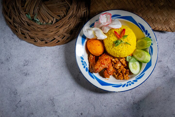 Indonesian traditional and signature dish, yellow rice served on an old plate. Top view with copy space.