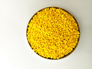 Yellow masterbatch granule, yellow polymer granules in a cup, cold cutting type granule texture,...