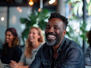 A cheerful man smiling in a collaborative workspace with friends, showcasing joy and teamwork in a modern office environment.
