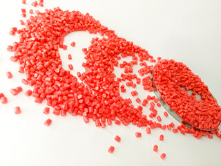 Red masterbatch granule, red pigment, red polymer granules in a cup, cold cutting type granule texture, isolated on white background, for industrial plastic company profile product catalog design
