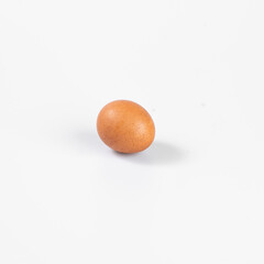 Minimalistic photo of a single brown egg isolated on a white background, showcasing simplicity and freshness in food photography.