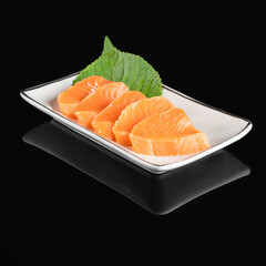 Plate of fresh salmon sashimi garnished with green leaf on a rectangular white plate against a black background.