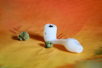 Marijuana glass pipe. Glass pipe or bong for marijuana cannabis smoking on an orange background.