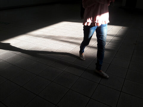 The shadow of the human foot is in the bright area of ​​the subway exit station, surrounded by shadows