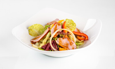 Fresh and colorful salad with ham, lettuce, tomato, and guacamole in a white bowl. A healthy and delicious meal option.