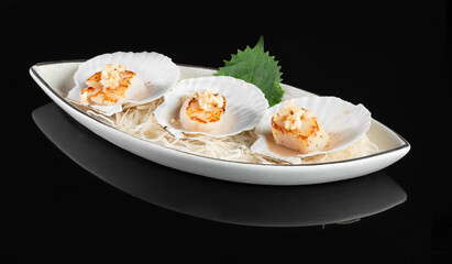 Gourmet scallops served on a stylish white platter, against a black background, arranged beautifully for a fine dining experience.