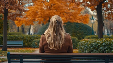Woman Sitting on a Bench in Autumn Park