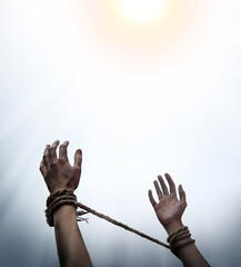 Tied hands raised to the sky