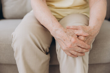Close-up aged female suffering on leg, pain knee from disease chronic, hand massage rubbing joint...